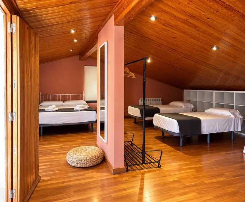 Overview of the attic with its beds and wooden ceiling