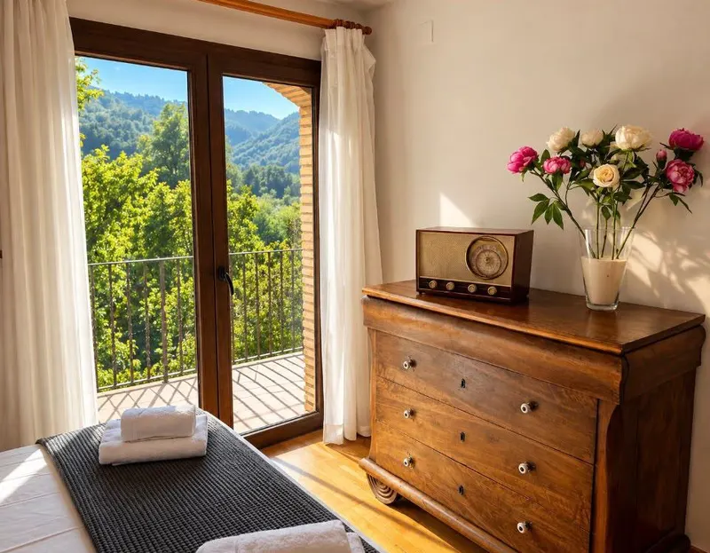 Pink double bedroom: antique chest of drawers and a glass door overlooking the trees