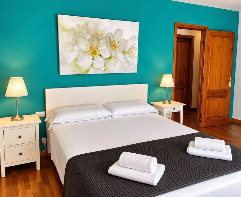 Blue double bedroom, with a double bed and a blue wall