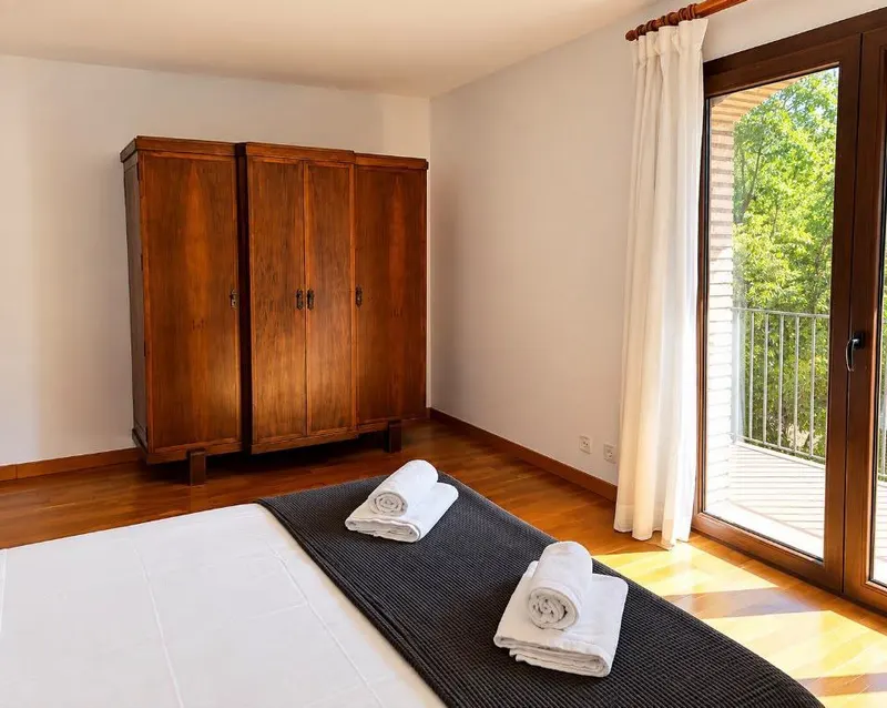 Blue double bedroom, with a wooden wardrobe and a door to the terrace