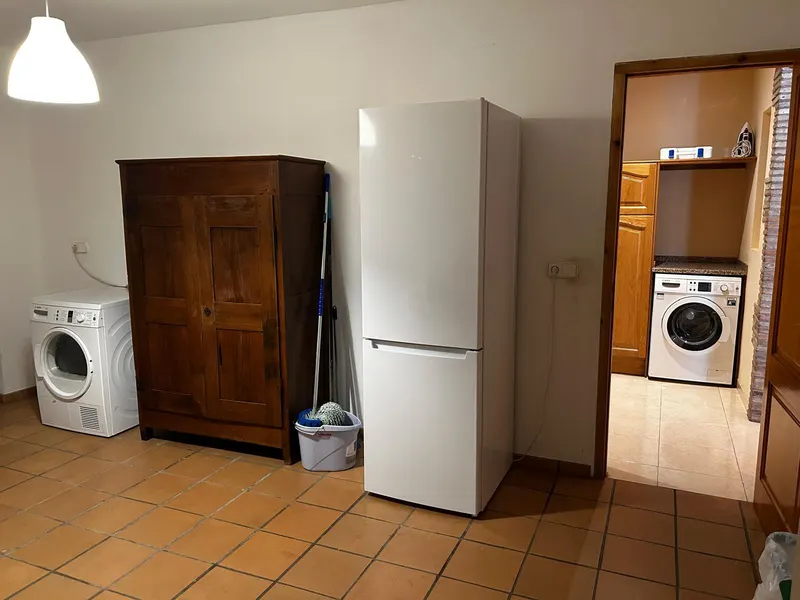 Laundry room with washing machine, cupboard and fridge