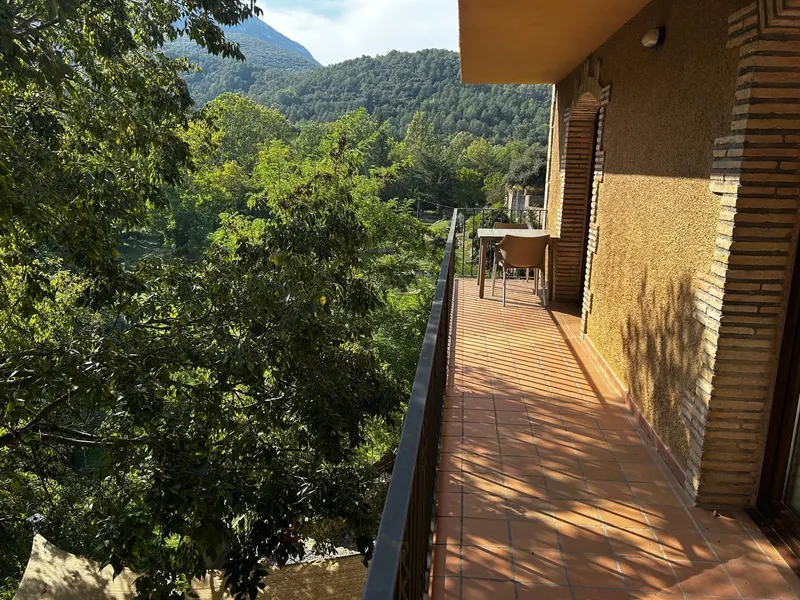 Terrassa allargada amb barana i vistes al bosc i la muntanya
